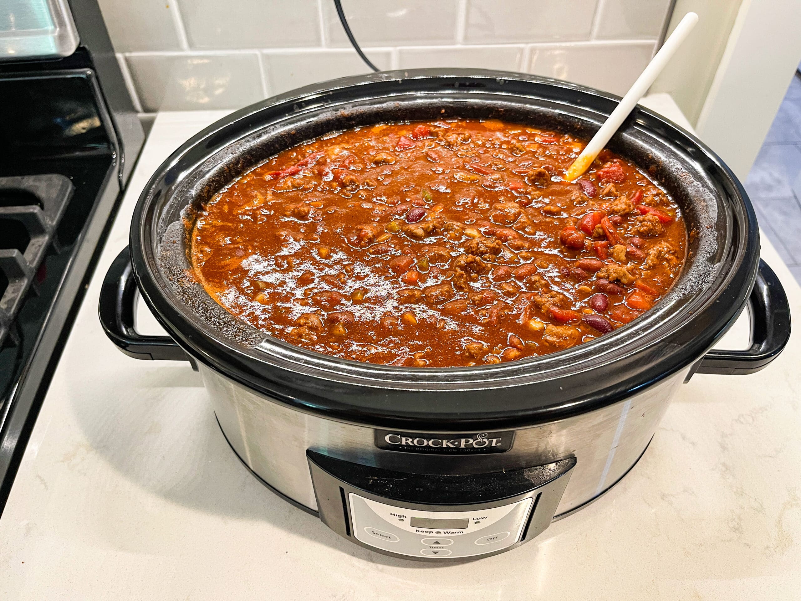 A full crockpot of simmering easy crockpot homemade chili, rich and hearty with beans and tomatoes.